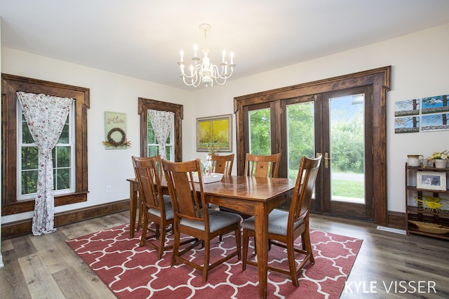 dining area featuring a notable chandelier, baseboards, and wood finished floors