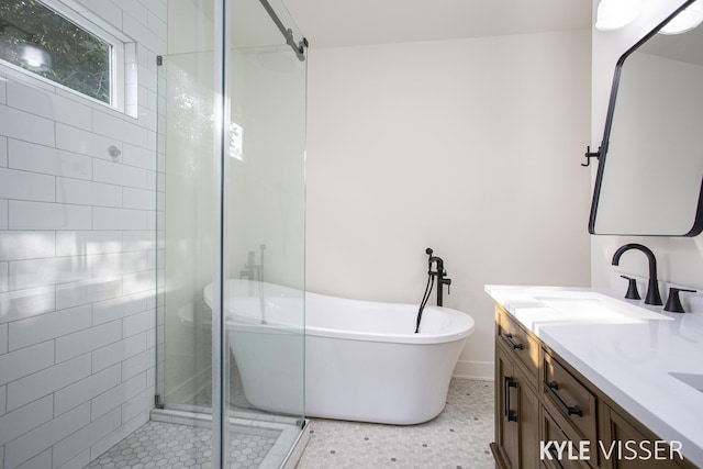 full bath with a stall shower, tile patterned flooring, a freestanding tub, and vanity