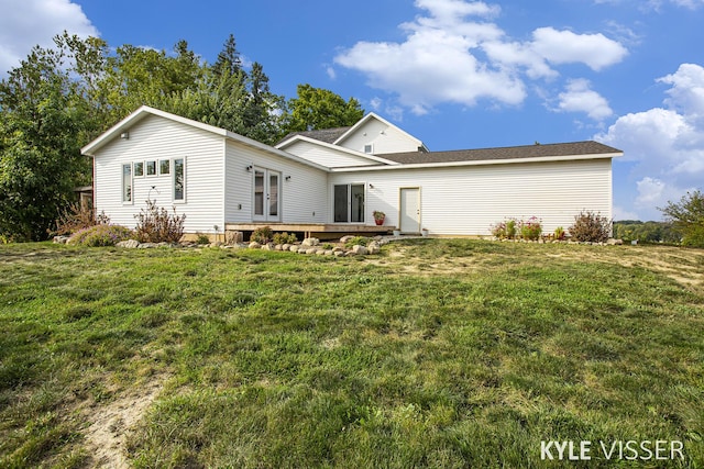 rear view of property with a wooden deck, a lawn, and french doors