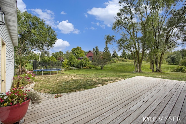 wooden deck featuring a yard and a trampoline