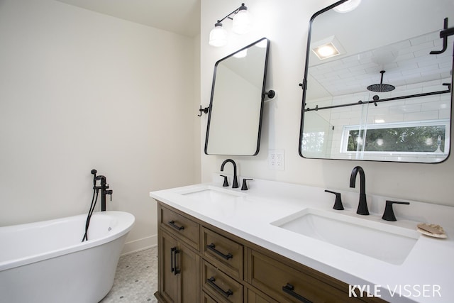 bathroom with a freestanding bath, double vanity, tiled shower, and a sink