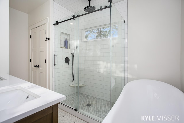 full bathroom with a soaking tub, a shower stall, and vanity