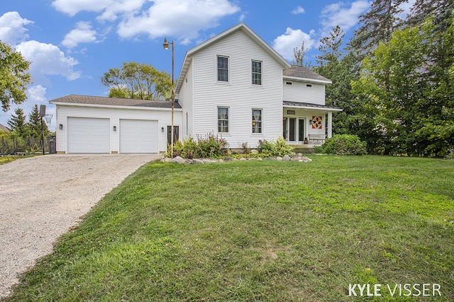 view of front of home with a garage, a front lawn, and gravel driveway