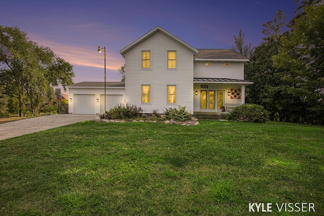 view of front of home with driveway, a garage, and a lawn