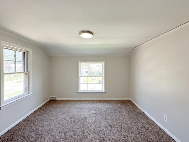 carpeted empty room featuring vaulted ceiling and ornamental molding