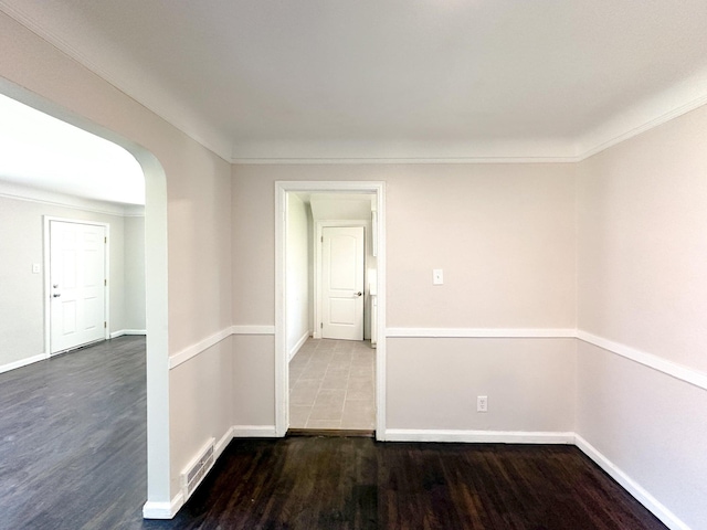 spare room with dark wood-type flooring and ornamental molding