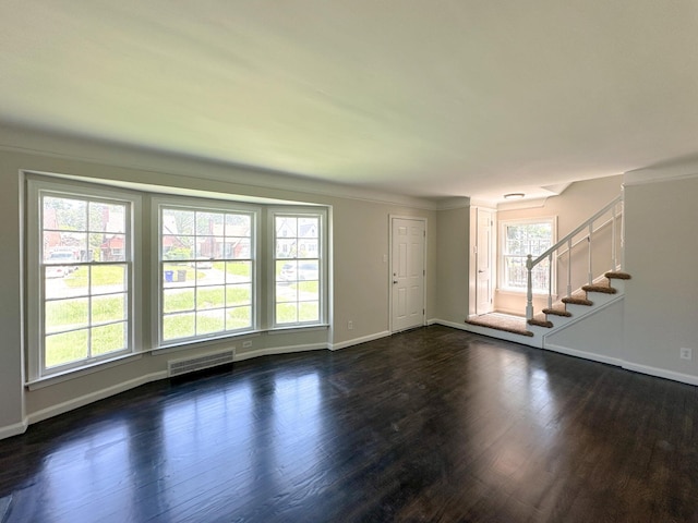 unfurnished living room with a wealth of natural light, crown molding, and dark hardwood / wood-style flooring