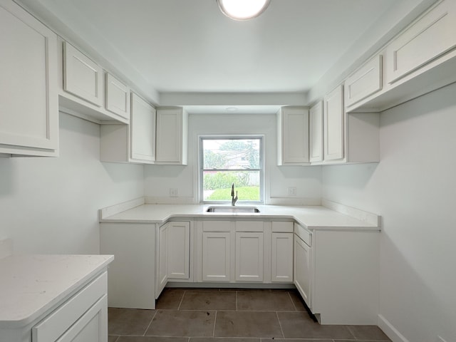 kitchen with sink, tile patterned floors, and white cabinetry