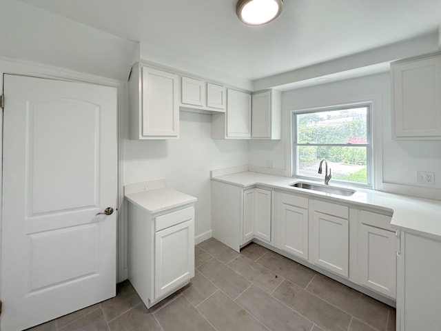 kitchen featuring sink, white cabinetry, and light tile patterned floors