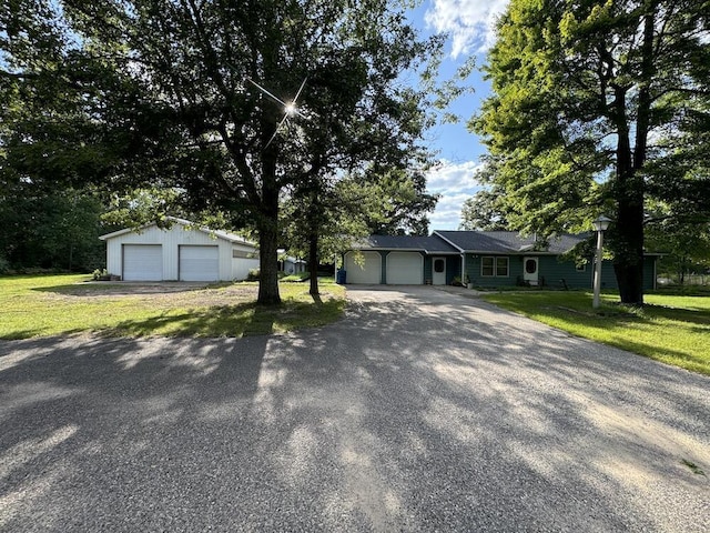 view of front of home featuring an outbuilding, a garage, and a front lawn