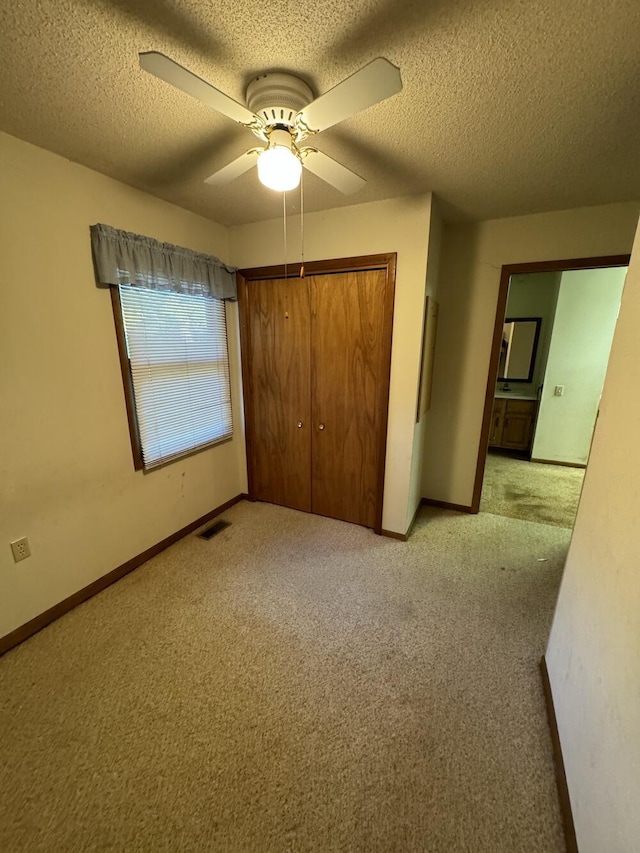 unfurnished bedroom with baseboards, visible vents, a closet, and light carpet