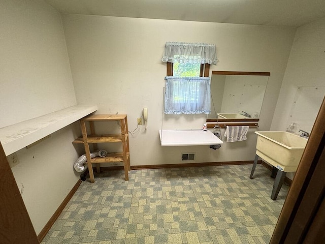 interior space featuring visible vents, carpet floors, baseboards, and a sink