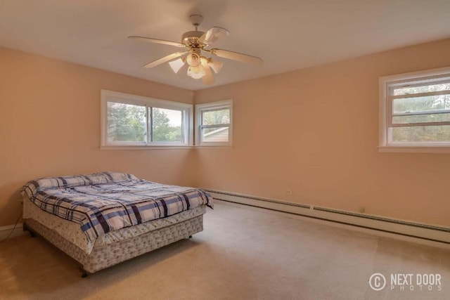 carpeted bedroom featuring baseboard heating and ceiling fan