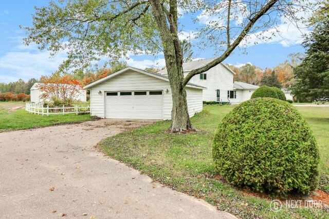 view of front of home featuring an outdoor structure, a front yard, and a garage