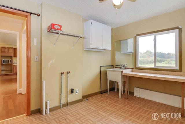 laundry room featuring ceiling fan and a textured ceiling