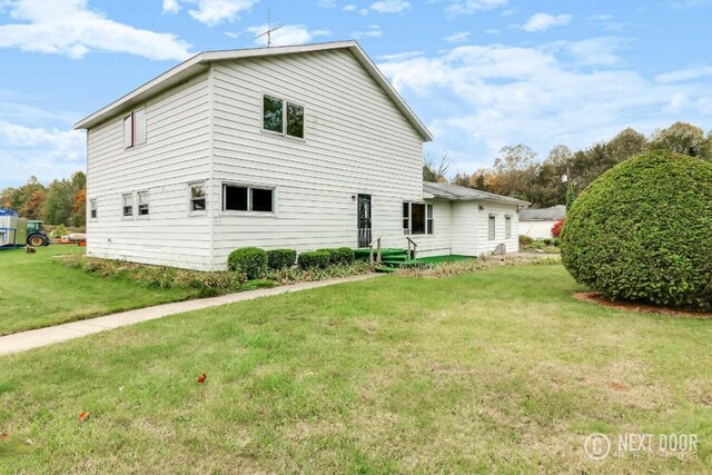 rear view of property featuring a lawn