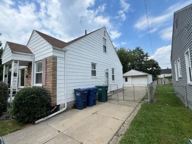 view of side of property with a yard, a garage, and an outdoor structure