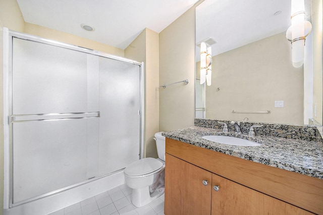 bathroom with vanity, a shower stall, toilet, and tile patterned floors