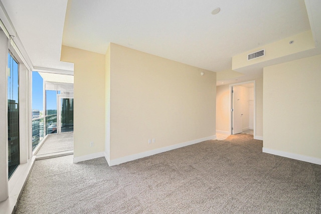 empty room with carpet floors, baseboards, and visible vents