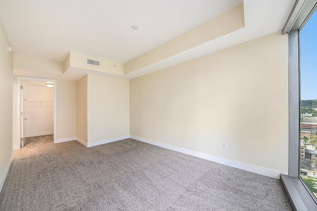 carpeted empty room with visible vents and baseboards