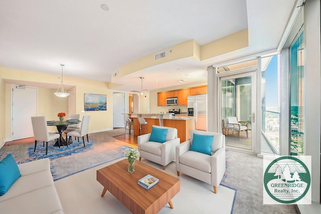 living area with a wall of windows and visible vents