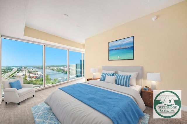 bedroom with a water view and light colored carpet