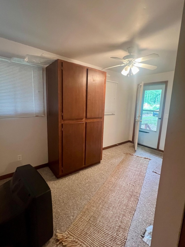 unfurnished bedroom featuring light colored carpet and ceiling fan