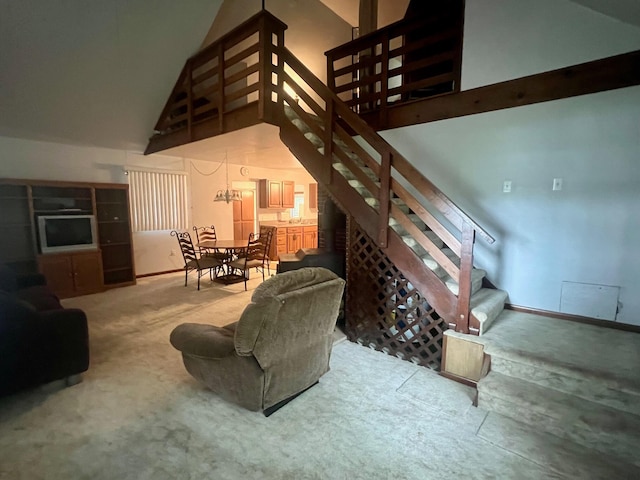 carpeted living room with high vaulted ceiling