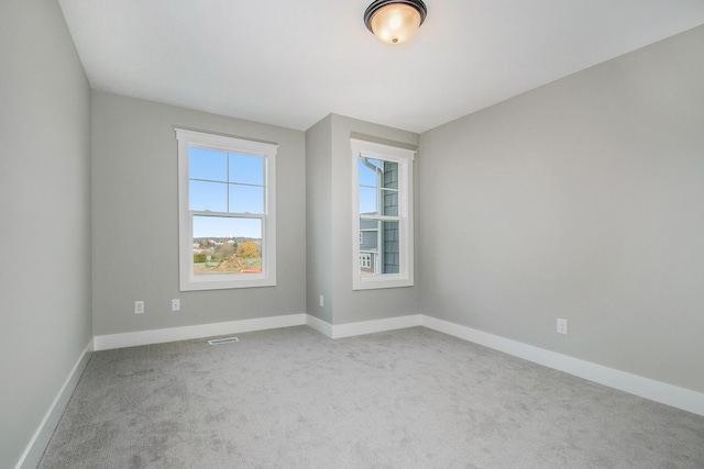 carpeted empty room featuring visible vents and baseboards