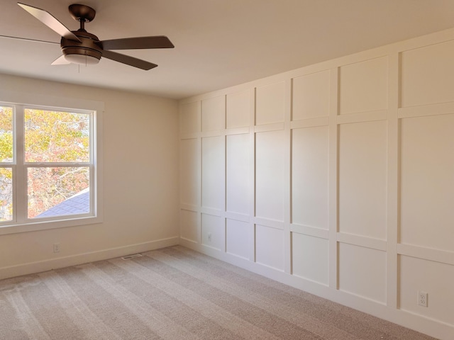 unfurnished bedroom with a ceiling fan, light carpet, and a decorative wall