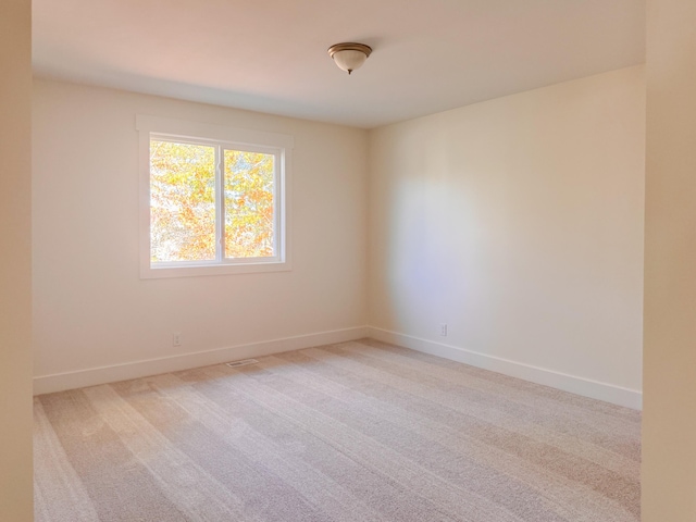 empty room featuring carpet floors and baseboards