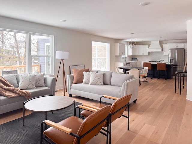 living area featuring light wood-type flooring and a healthy amount of sunlight