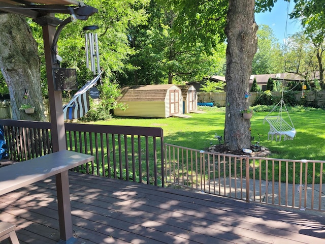 wooden terrace featuring a storage unit and a lawn