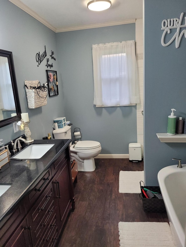 bathroom with vanity, wood-type flooring, crown molding, toilet, and a washtub