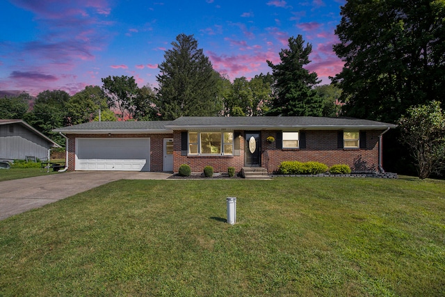 single story home featuring a garage and a yard