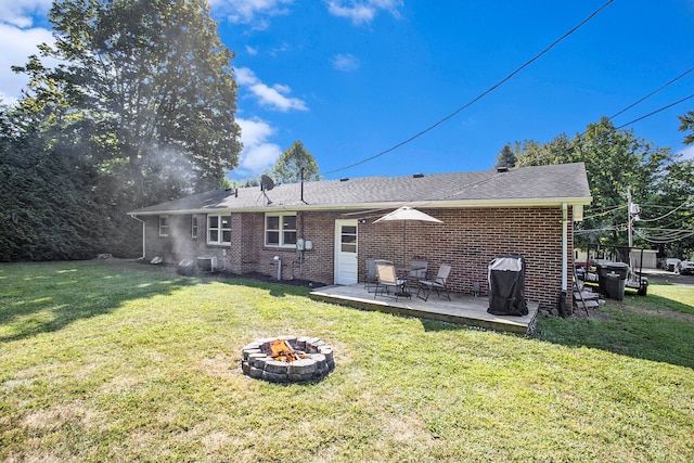 back of house featuring a fire pit, a lawn, and a patio