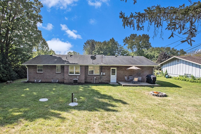 rear view of property featuring a fire pit, a yard, and cooling unit