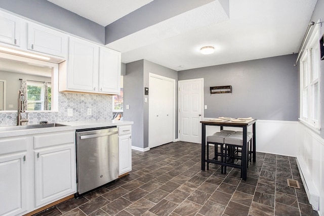 kitchen featuring white cabinets, backsplash, dishwasher, dark tile patterned floors, and sink