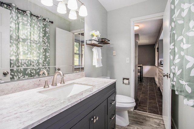 bathroom with vanity, toilet, and wood-type flooring