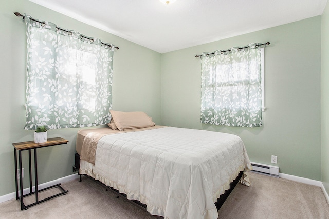 bedroom with a baseboard heating unit and light carpet