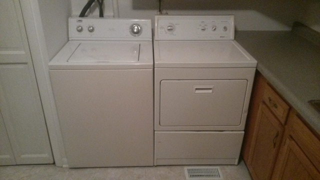 washroom with light tile patterned floors and separate washer and dryer