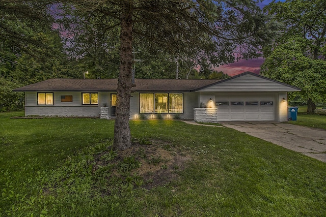 ranch-style home featuring concrete driveway, brick siding, a yard, and an attached garage