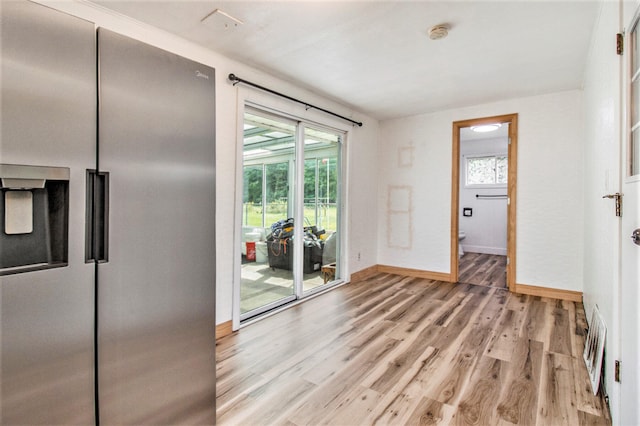 doorway to outside with light wood-type flooring and a healthy amount of sunlight