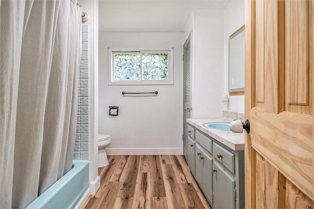 full bathroom with vanity, toilet, hardwood / wood-style floors, and shower / bathtub combination with curtain