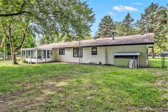 back of property featuring a lawn and a sunroom