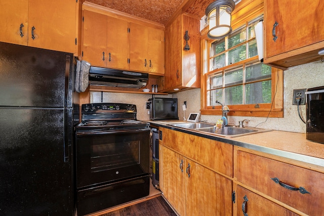 kitchen featuring black appliances, sink, dark hardwood / wood-style flooring, and extractor fan