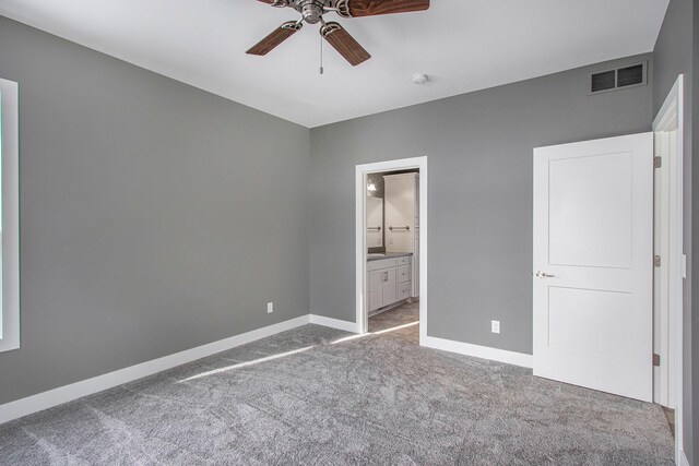 unfurnished bedroom featuring carpet flooring, ceiling fan, and ensuite bath