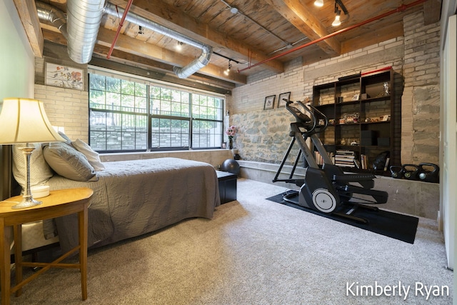 bedroom with brick wall, track lighting, and carpet