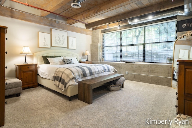 carpeted bedroom with beamed ceiling, wood ceiling, and rail lighting