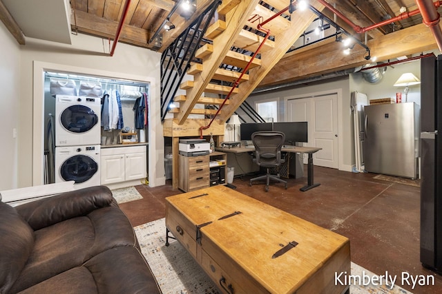 living room with wood ceiling and stacked washer / dryer